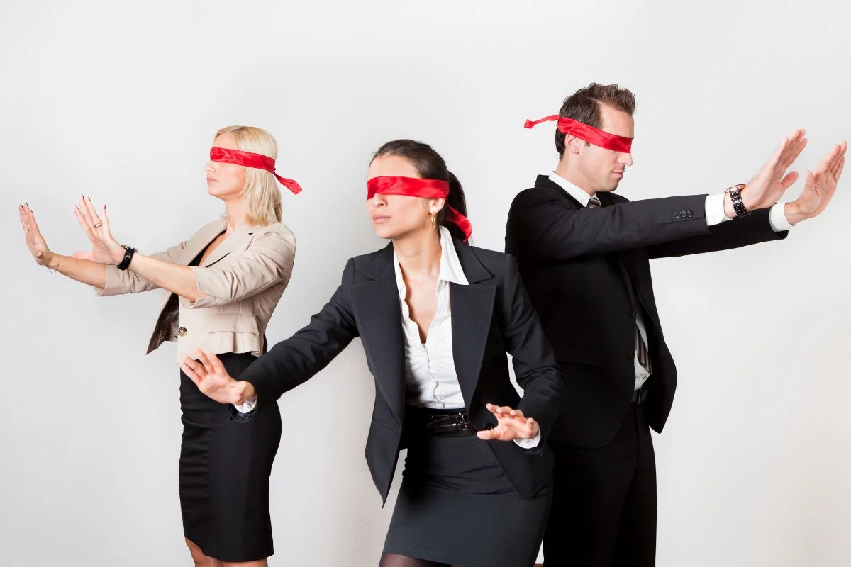 Three business people wearing blindfolds | Axiom Communications
